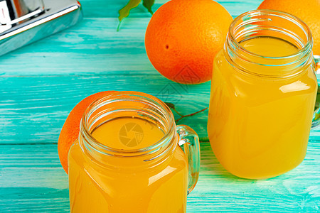 绿色木制桌上有橙汁的玻璃杯饮食桌子玻璃水果早餐橙子饮料木头黄色乡村图片