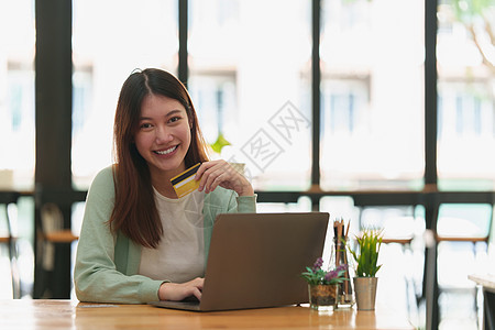 使用在线付款和持有信用卡的妇女 网上购物概念 见信用购物网站电子商务安全顾客折扣产品金融销售图片