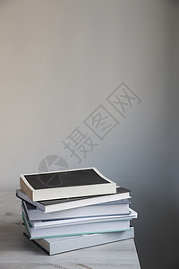 黑白墙对面的米色桌上有一堆书 斯堪的纳维亚风格 最小化 文本的位置图片