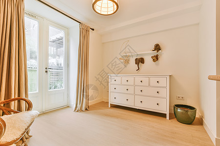 现代公寓内一个房间的内部内部吊灯枝形风格家具装饰绘画凳子房子植物木地板图片