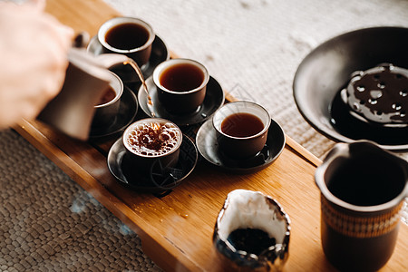 在一家大公司举行茶仪式时 为茶会特写倒茶开水文化礼仪茶杯木头浓茶陶瓷菜肴杯子传统图片