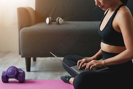 在家练习瑜伽的年轻女性在笔记本电脑在线课程中跟随教师 冷静和放松概念视频班级训练运动身体哈达地面运动员健康房间图片
