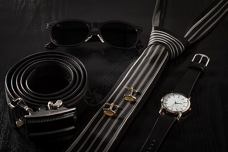 黑色背景男子的服装和配件 表情手腕腰带袖扣领带男人金属手表丝绸太阳镜奢华图片