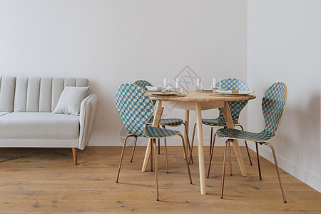 客厅现代风格的内部配有灰色布艺沙发 供少数人使用的餐桌和带装饰的椅子图片