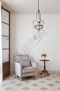 室内客厅 白色墙附近有舒适的手椅和侧桌 用老式吊灯进行回转风格图片