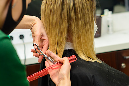 理发师在理发店理发 把头发的尾端整齐发型顾客店铺金发女郎客户发型师微笑护理沙龙治疗图片