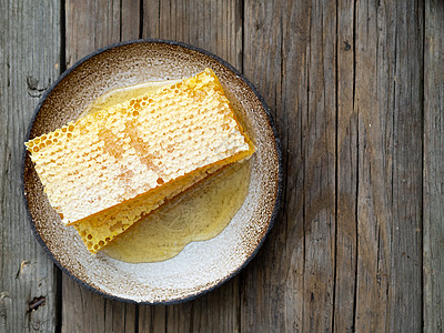 蜂蜜中的蜂蜜 特写 白色陶瓷板 木制生锈的桌子甜点蜂窝美食食物草本植物蜜蜂营养液体木头乡村图片