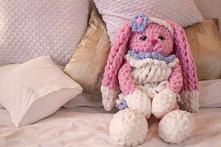 粉红兔子编织玩具坐在沙发上 动物编织 Amigurumi钩针娃娃爱好喜悦毛绒手工幸福乐趣艺术婴儿图片