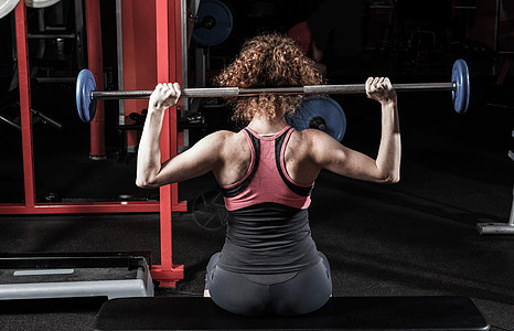 健身房的女健体建筑师 在健身房里跟一个酒吧铃健美运动金属力量女士训练重量身体运动员能力图片