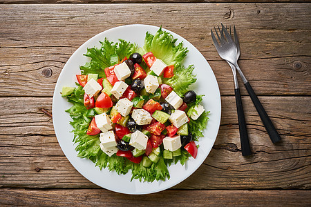 白板上的希腊沙拉 在古老的铁制木制桌子上 顶层风景维生素叶子面包午餐盘子乳酪早餐蔬菜营养小吃图片