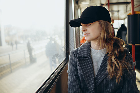 可悲的是 年轻女子向车窗外看望 戴耳机旅游乘客悲伤情感孤独过境寂寞公共汽车女孩民众图片