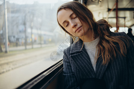 可悲的是 年轻女子向车窗外看望 戴耳机乘客游客情感交通公共汽车女孩孤独寂寞悲伤女性图片