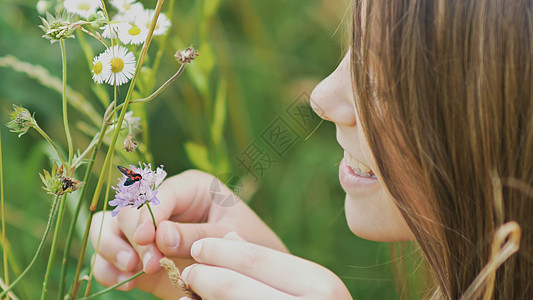 少女崇拜花上的飞蛾 温暖的夏日生长快乐昆虫孩子们乐趣自由女孩花束青年手指图片