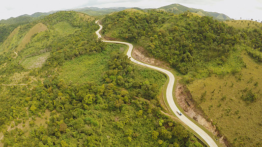 一条长长而曲折的道路穿过绿山 布苏安加岛 科隆 空中视线 菲律宾农村蓝色车道阳光妈妈旅行踪迹顶峰森林天空图片