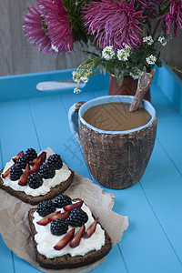 甜奶酪和浆果三明治 蓝木本底一杯咖啡的咖啡勺子水果桌子托盘饮食手工面包杯子小吃蓝色图片