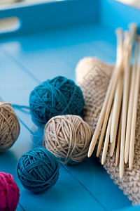 光亮的毛线球 木编织针头 蓝背景的毛毯木头织物装饰品针织家庭情绪礼物图片
