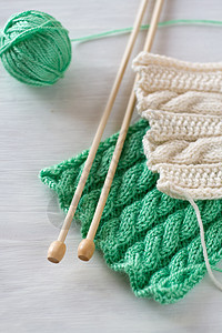 两种亮光图案和白色背景的木编织针头线程针织爱好绿色配饰背景图片