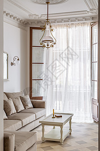 客厅以古老的风格装饰 用瓷地板 打开阳台和挥舞窗帘 从走廊到沙发 咖啡桌和回旋吊灯都能看到图片