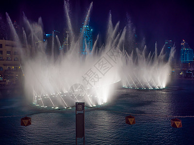 迪拜塔夜里在城里用灯光跳舞的喷泉办公室投影机吸引力乐趣展示旅游市中心民众照明购物中心背景