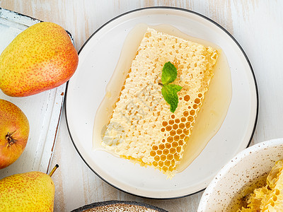 蜂蜜中的蜂蜜 特制 陶瓷板上 白色木制生锈桌子上 平铺图片