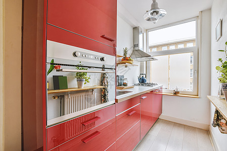 红色设计中舒适厨房的内室内橱柜建筑学装饰台面厨具风格木地板烤箱内阁几何学图片