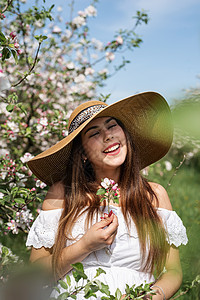 年轻的caucasian年轻女人 享受着苹果树的开花幸福花朵花园公园女孩黑发叶子女士植物群女性图片