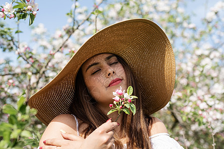 年轻的caucasian年轻女人 享受着苹果树的开花女士女孩花园季节公园植物群黑发女性花朵香气图片