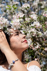 年轻的caucasian年轻女人 享受着苹果树的开花公园女士黑发花朵叶子季节女性花园女孩植物群图片