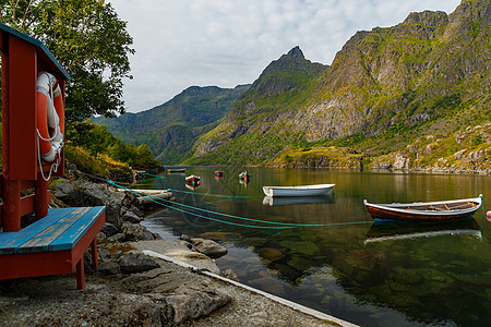 挪威山湖风景如画的海岸靠近罗弗敦群岛 渔船 绿草覆盖的山坡被阳光照亮 最纯净的水反射峡湾天空日落旅游假期悬崖爬坡蓝色海滩图片