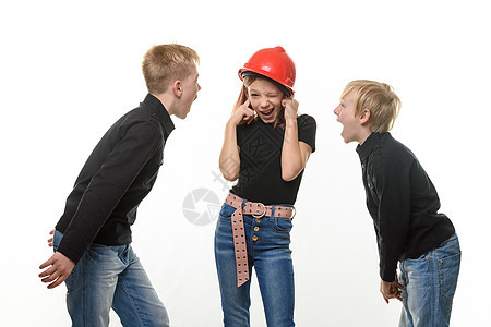 两个男孩在对一个女孩大喊大叫 女孩戴着头盔站在头盔里堵着耳朵图片