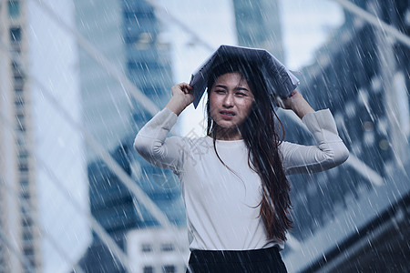 在暴风雨中的女孩头顶上 报纸为经济障碍的通过概念而刻画图片