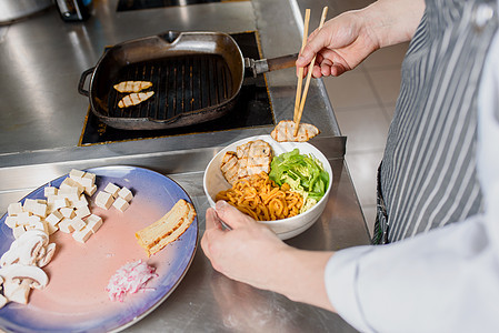 炸鸡柳放在盘子里 厨师为拉面汤煮意大利面条 用肉 蘑菇 萝卜 鸡蛋煮拉面汤图片