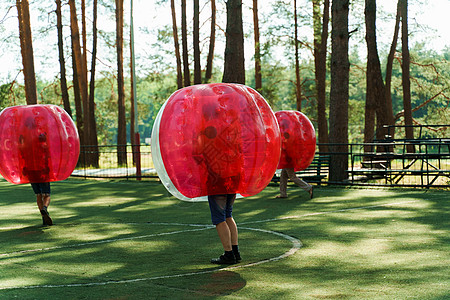 泡泡足球运动游戏 足球运动员在绿地上玩碰碰球 团队建设 泡泡气球奔跑的人比赛塑料青少年玩家公园女孩太空空气行动滚球图片