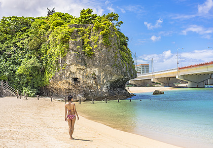 身穿泳衣的年轻女子 在冲绳岛纳米诺乌海滩后面图片