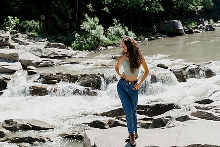 山河的瀑布 女孩正在卡尔巴斯蒂安山上旅行 感受自由 连带瀑布和美丽的年轻女子愁云公园热带流动风景森林环境岩石下雨力量图片