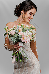 有婚礼花束的新娘看右边并且微笑 社交网络的迷人女孩垂直肖像 空白背景中穿着婚纱的女孩图片