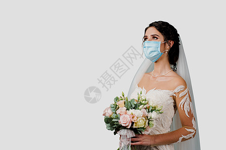 在Corona病毒 Covid 19隔离期 戴医疗面具和婚礼花束的新娘裙子工作室婚纱奢华女士快乐订婚成人花朵幸福图片