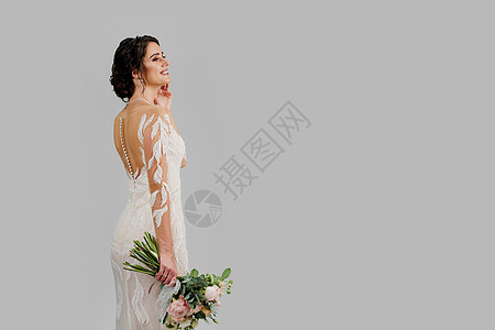 新娘在豪华婚纱与花束在白色空白背景右侧的工作室 为婚庆公司和婚纱沙龙的社交网络做广告图片