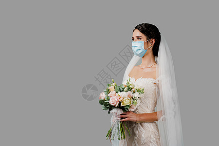在Corona病毒 Covid 19隔离期 戴医疗面具和婚礼花束的新娘婚纱花朵奢华发型庆典优雅女士女性成人裙子图片