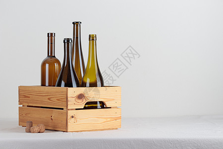 桌上盒子里的绿色葡萄酒瓶食物产品液体酒吧白色木头标签啤酒空白饮料图片