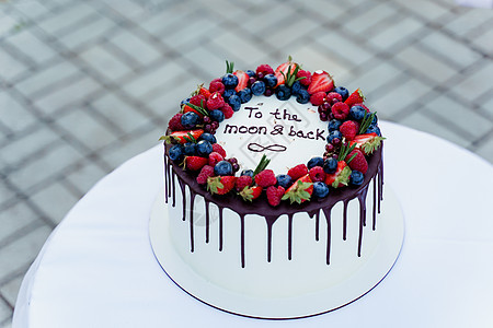 上面有草莓和蓝莓的婚礼蛋糕 为仪式准备白美味的蛋糕 给厨师做广告食物男人派对新娘夫妻巧克力庆典桌子结婚甜点图片