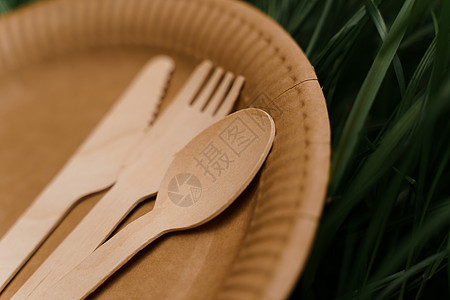 带勺子 叉子 刀子的特写生态天然盘子 套在绿草背景的一次性生态盘子 地球的可持续性午餐纸盒餐具食物咖啡环境工艺静物材料浪费图片