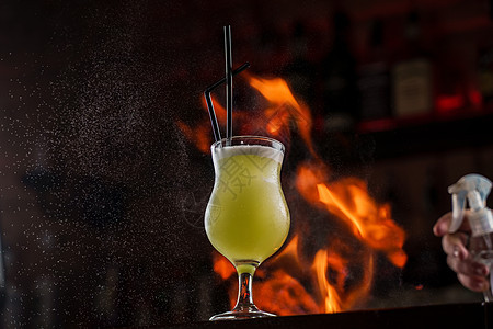 酒保洒在光亮玻璃上 酒吧柜台有明绿色的冷水鸡尾酒 上面放着火焰饮料果汁橙子酒精杯子派对酒杯液体庆典柠檬图片