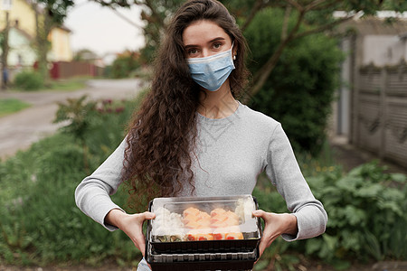 配有2个寿司盒的医疗面具的女信使站在车前 寿司装在用汽车提供健康食品服务的箱中手套产品疾病防御酱油感染外卖消毒海鲜导游图片