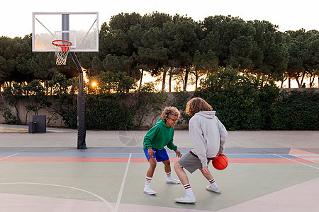 两位年轻朋友在市法院打篮球街道练习男人法庭运动训练城市成人男性友谊图片