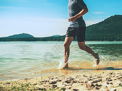 赤脚运动员在沙沙滩一带的水中奔跑图片