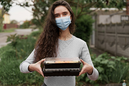 配有2个寿司盒的医疗面具的女信使站在车前 寿司装在用汽车提供健康食品服务的箱中防御食物手套感染消毒海鲜餐厅酱油产品疾病图片