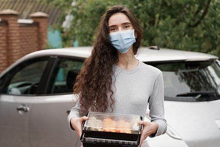 配有2个寿司盒的女信使戴医疗面具 站在车前站立着两个寿司箱感染海鲜酱油消毒餐厅产品寿司防御食物外卖图片