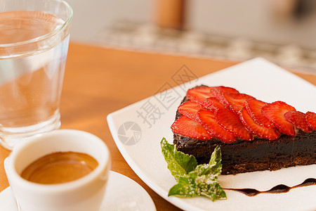 巧克力蛋糕 巧克力蛋糕 草莓和薄荷 浓咖啡 木桌上的水盘子桌子甜点糕点冷却午餐奶油蛋糕美食食物图片