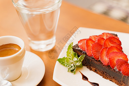 巧克力蛋糕 巧克力蛋糕 草莓和薄荷 浓咖啡 木桌上的水美食馅饼糕点桌子早餐面包餐厅玻璃可可午餐图片